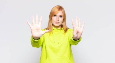 Kızıl saçlı güzel bir kadın gülümsüyor ve arkadaş canlısı görünüyor. Dokuz ya da dokuzuncu eli önde, geriye doğru sayıyor.