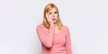 Kızıl saçlı güzel bir kadın yorgun, sıkıcı ve sıkıcı bir işten sonra sıkılmış, hayal kırıklığına uğramış ve uykulu hisseder.