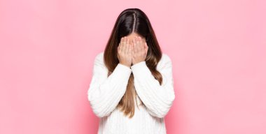 Genç, güzel bir kadın üzgün, hayal kırıklığına uğramış, gergin ve depresif hissediyor. İki eliyle yüzünü kapatıyor, ağlıyor.