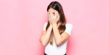 Genç, güzel bir kadın korkmuş ya da utanmış hissediyor. Gözleri yarı kapalı ya da ellerle dikizliyor.