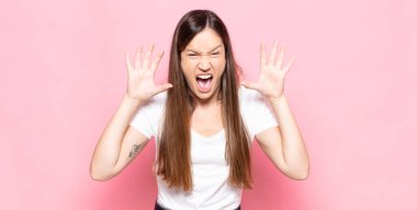 Genç, güzel bir kadın panik ya da öfke içinde bağırıyor. Şok olmuş, korkmuş ya da öfkeli. Elleri başının yanında.