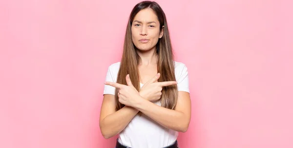 Jovem Bonita Mulher Olhando Confuso Confuso Inseguro Apontando Direções Opostas — Fotografia de Stock