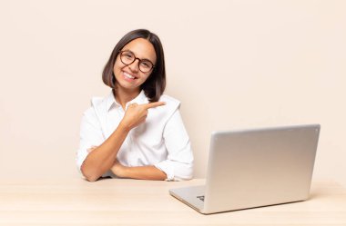 Neşeli bir şekilde gülümseyen, mutlu hisseden, kenarı ve yukarıyı gösteren, kopya uzayda nesneleri gösteren