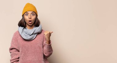 Genç bir kadın sinirli, sinirli, kızgın bakışlar ve sıkı yumruklarla bağırıyor, öfkeli hissediyor.