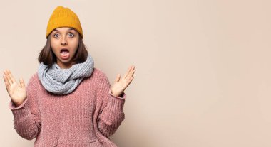 Genç kadın gülümsüyor, mutlu, kaygısız ve tatmin olmuş hissediyor, fotokopi alanındaki konsepte ya da fikre işaret ediyor.