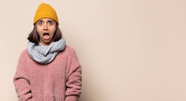 Genç kadın üzgün, incinmiş ve kalbi kırık görünüyor, iki elini de kalbe yakın tutuyor, ağlıyor ve depresyonda.