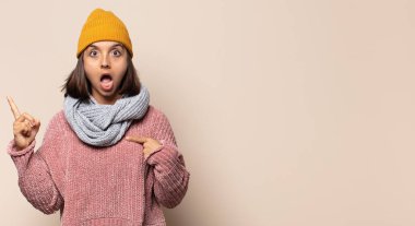 Genç bir kadın gülümsüyor ve arkadaş canlısı görünüyor. Üç ya da üç numarayı gösteriyor. Elleri önde, geri sayıyor.