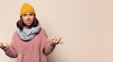 Genç bir kadın gülümsüyor ve dost canlısı görünüyor, 7 ya da 7 numarayı gösteriyor, eli önde, geriye doğru sayıyor.