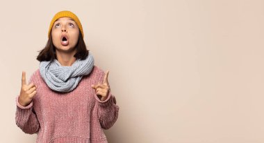 Genç bayan gülümsüyor ve arkadaş canlısı görünüyor, 8 ya da 8 numarayı gösteriyor, elleri önde, geri sayıyor.