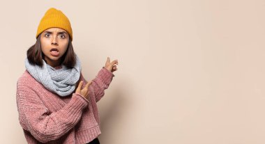 Şok olmuş ve ağzı açık, kendini işaret eden genç bir kadın.