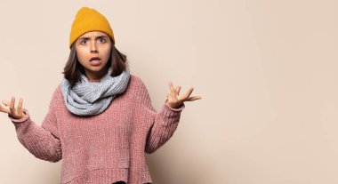 Genç bir kadın korkmuş ya da utanmış hisseder. Gözleri yarı kapalı bir şekilde dikizler ya da gözetler.