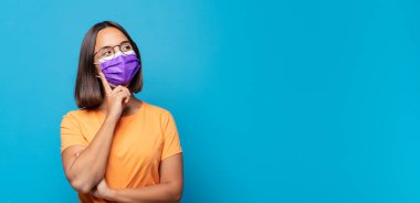 Genç kadın mutlu bir şekilde gülümsüyor ve hayal kuruyor ya da şüphe ediyor.