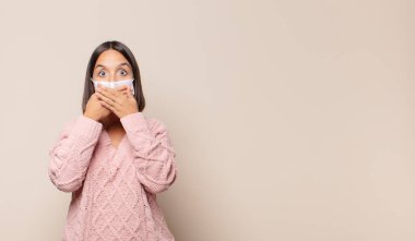 Şok olmuş, şaşırmış bir ifadeyle ağzı kapatan genç bir kadın sır saklıyor ya da 