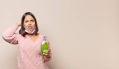 Genç bir kadın kendini stresli, endişeli, endişeli ya da korkmuş hissediyor. Elleri başının üstünde, hatayla panikliyor.