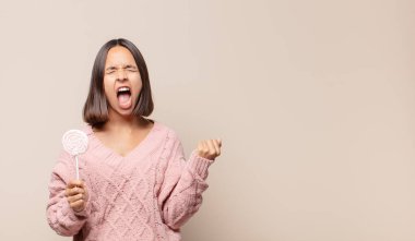 Saldırgan bir ifadeyle bağıran genç bir kadın ya da yumruklarıyla başarıyı kutlayan.