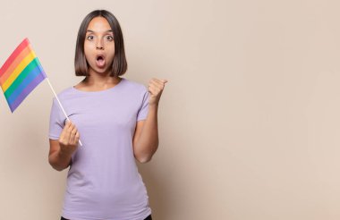 İnançsızlıktan hayrete düşmüş genç bir kadın, yan taraftaki objeyi işaret ederek, 