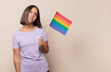 young woman feeling puzzled and confused, with a dumb, stunned expression looking at something unexpected