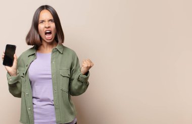 Saldırgan bir ifadeyle bağıran genç bir kadın ya da yumruklarıyla başarıyı kutlayan.