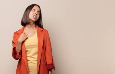 Genç bir kadın stresli, endişeli, yorgun ve hayal kırıklığına uğramış, gömleğini çekmiş, sıkıntılı görünüyor.