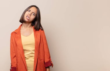 young woman feeling puzzled and confused, with a dumb, stunned expression looking at something unexpected