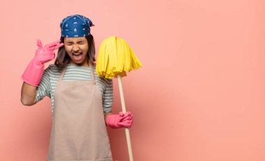 Genç kadın hizmetçi mutsuz ve stresli görünüyor, intihar jesti elle silah işareti yapıyor, kafasını işaret ediyor.