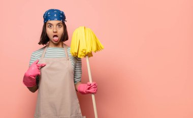 Genç kadın hizmetçi ağzı açık, şaşkın ve şaşırmış görünüyor, kendini işaret ediyor.