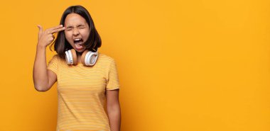 Mutsuz ve stresli görünüyor, intihar jesti elle silah işareti yapıyor, kafasını işaret ediyor.