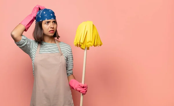 Young Woman Housekeeper Feeling Puzzled Confused Scratching Head Looking Side — Stock Photo, Image