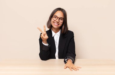 Gülümseyen ve mutlu görünen, kaygısız ve pozitif, tek elle zafer ya da barış işareti yapan