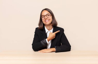 Neşeli bir şekilde gülümseyen, mutlu hisseden, kenarı ve yukarıyı gösteren, kopya uzayda nesneleri gösteren