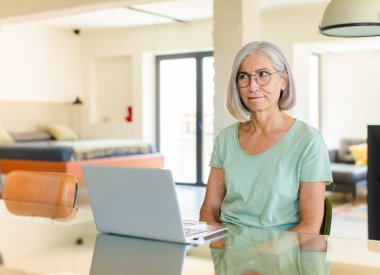 Orta yaşlı kadın şaşkın ve şaşkın görünüyor. Sinirli bir hareketle dudağını ısırıyor. Sorunun cevabını bilmiyor.