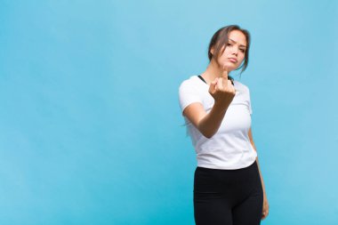 Genç İspanyol kadın kızgın, sinirli, asi ve agresif hissediyor. Orta parmağını sallıyor, karşı koyuyor.