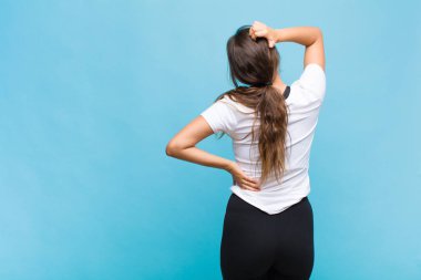 Genç İspanyol kadın bilgisiz ve şaşkın hissediyor, bir çözüm düşünüyor, eli kalçasında, diğeri kafasında, dikiz aynasından.