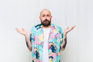 Kel adam şaşkın ve kafası karışık, şüpheci, farklı seçenekleri tartıyor ya da komik bir ifadeyle seçiyor