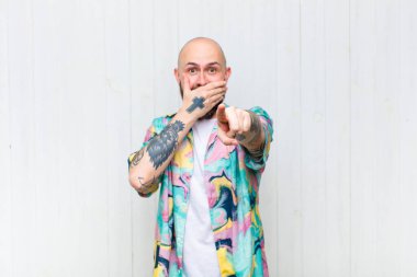 Kel adam sana gülüyor, kamerayı işaret ediyor ve seninle dalga geçiyor ya da alay ediyor.