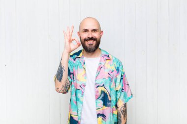 Kel adam mutlu, rahat ve tatmin olmuş hissediyor. Onayını iyi bir hareketle gösteriyor. Gülümsüyor.