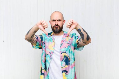 Kel adam üzgün, hayal kırıklığına uğramış ya da kızgın görünüyor. Anlaşmazlıkta baş parmağını gösteriyor. Hayal kırıklığına uğramış hissediyor.