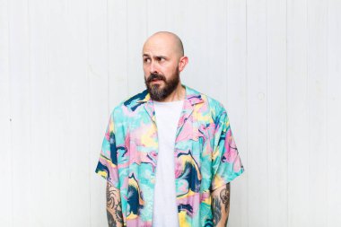 Kel adam endişeli, stresli, endişeli ve korkmuş görünüyor, panikliyor ve dişlerini sıkıyor