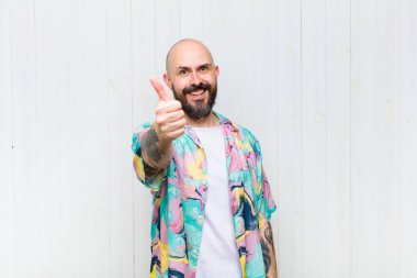 Kel adam gururlu, kaygısız, kendinden emin ve mutlu, olumlu gülümsüyor.