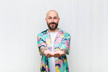 Dost canlısı, kendine güvenen, olumlu bakışlı, bir nesne ya da konsept sunan ve gösteren kel bir adam.