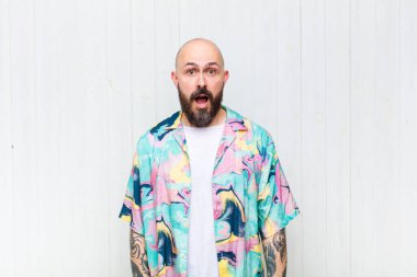 Kel adam şok olmuş ya da şaşırmış görünüyor, ağzı açık bir şekilde 