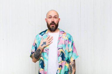 Kel adam şaşkın, şaşkın ve şaşırmış hissediyor, elleri göğsünde ve ağzı açık, kim olduğunu söylüyor, ben mi??