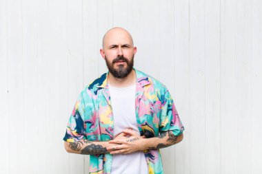 Kel bir adam endişeli, hasta, hasta ve mutsuz. Ağrılı bir mide ağrısı ya da grip geçiriyor.