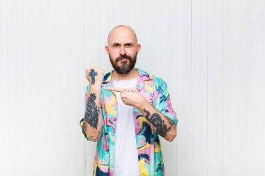 Kel adam sabırsız ve kızgın görünüyor, saati gösteriyor, dakiklik istiyor, zamanında gelmek istiyor.