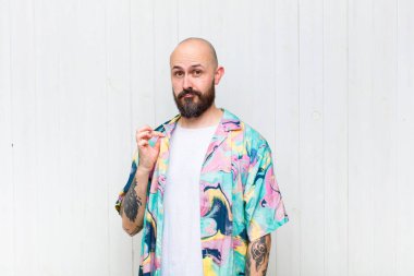 Kel adam kibirli, başarılı, pozitif ve gururlu görünüyor, kendini işaret ediyor.