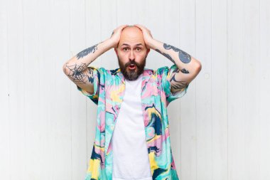 Kel adam heyecanlı ve şaşırmış görünüyor, ağzı açık, elleri başının üstünde, şanslı bir kazanan gibi hissediyor.