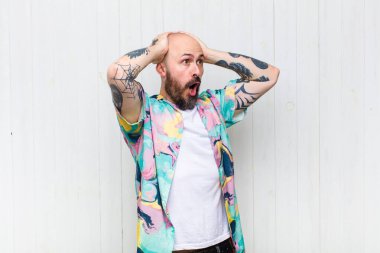 Kel ve ağzı açık bir adam, korkunç ve şok olmuş görünüyor korkunç bir hata yüzünden, kafa kafaya eller kaldırarak