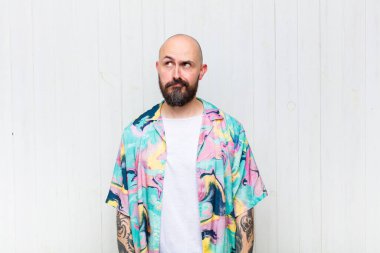 Kafası karışmış, kafası karışmış, bir sorunu çözmeye çalışan ya da düşünen kel bir adam.