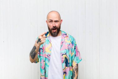 Kızgın agresif bir ifadeyle kameraya bakan kel bir adam kızgın, çılgın bir patron gibi görünüyor.