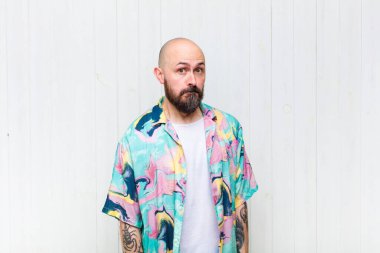 Kel, çılgın, şaşırmış bir ifadesi olan, yanakları şişen, doldurulmuş, şişman ve yemekle dolu bir adam.